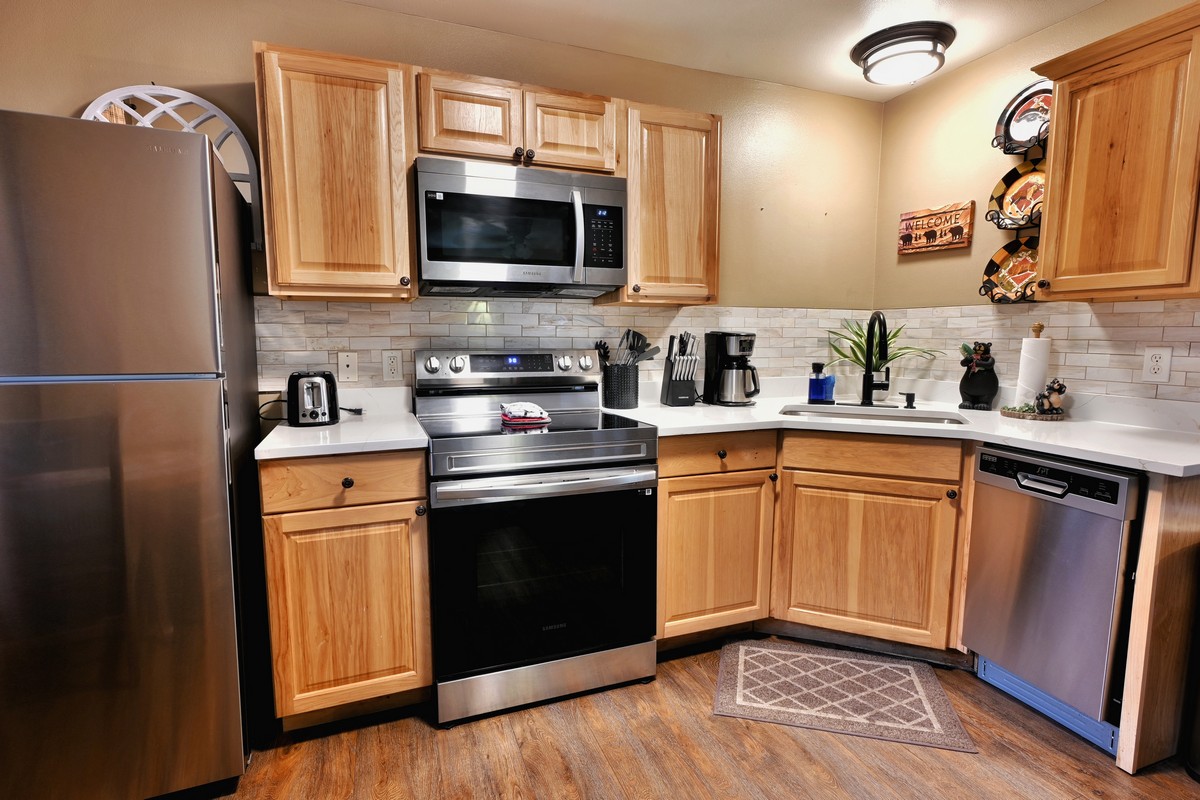Fully equipped kitchen in the Pine Cone Cabin at Fall River Cabins, featuring stainless steel appliances and modern cabinetry.